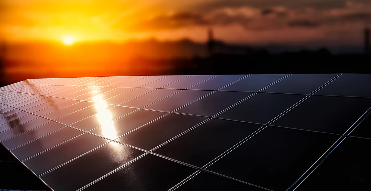 Panneau photovoltaïque au soleil couchant, reflet doré sur les cellules.
